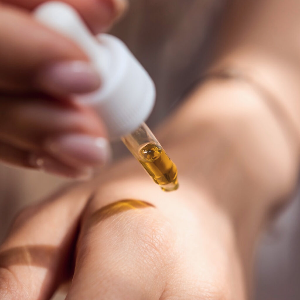 A closeup of a Harmonized Aesthetics patients applying a vitamin C serum to their hand. Serums rich in vitamin C inhibit the skin's production of melanin, which helps the results of a hyperpigmentation treatment in Tallahassee last longer.