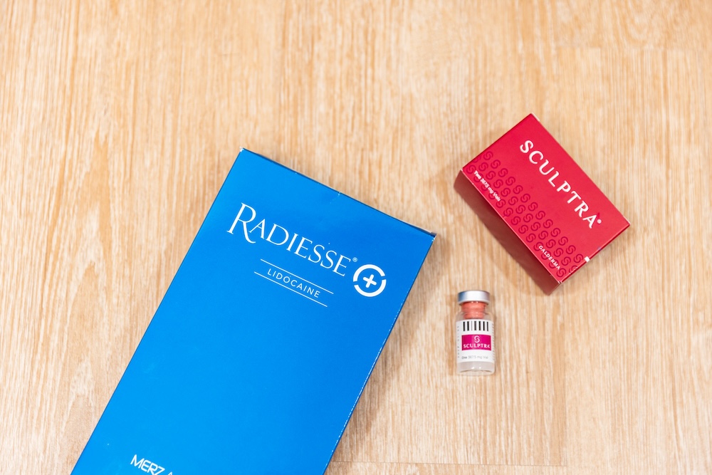 Boxes of biostimulators available at Harmonized Aesthetics sit next to each other on a tabletop. One of those is a box of Radiesse injections in Thomasville.